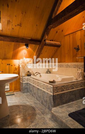 Rustikales schickes Badezimmer mit ummantelter Badewanne im Obergeschoss im alten, ca. 1740 Jahre alten Haus im kanadischen Cottage-Stil. Stockfoto