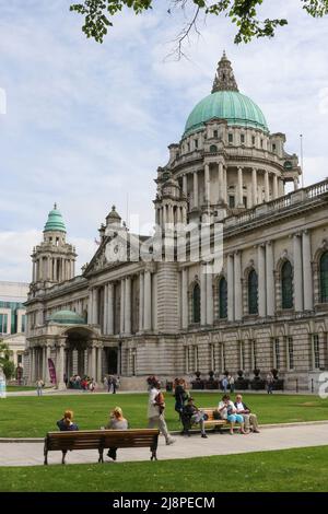 Sommertag im Zentrum von Belfast, mit Menschen, die sich ausruhen und auf dem Gelände des Belfast City Hall, Nordirland, spazieren gehen. Stockfoto