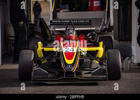 Die gelbe und rote Nummer 24 Australien Formel 3 Auto sitzt in der Pitlane kurz vor dem Start zum Test auf Winton Motor Raceway. Stockfoto