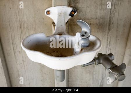 Ein alter Vintage Trinkbrunnen. Dieses Haus wurde seitdem abgerissen. Stockfoto