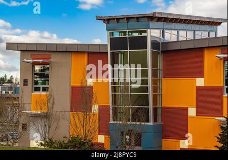 Mehrfarbige Fassaden der Schule mit Fensterrahmen. Modernes Äußeres eines farbenfrohen Bürogebäudes Stockfoto