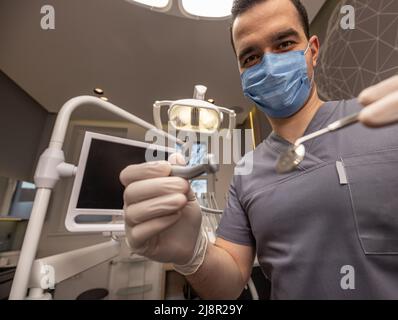 Professioneller männlicher Zahnarzt, der zahnärztliche Instrumente hält. Zahnmedizin Konzept Stockfoto
