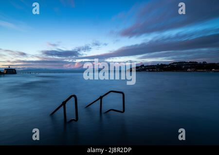 Clevedon Marine Lake, Großbritannien. 17.. Mai 2022. Ein Blick auf die Stufen zum Betreten des Marine Lake, während die aufsteigende Flut während der Flut in Somerset die Meeresmauer überflutet Quelle: steven paston/Alamy Live News Stockfoto