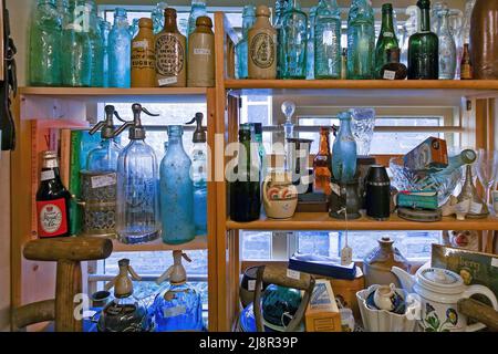 Sortiment an alten Vintage-Glasflaschen und -Behältern auf Regalen in Antiquitätenläden, Uppingham, England, Großbritannien Stockfoto