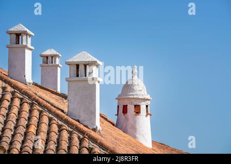 Traditionelle weiße Kamine über einer Dachziegel in Cáceres Spanien Stockfoto