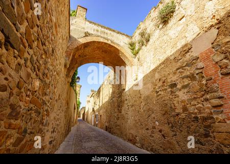 Schmale Straße in der Altstadt von Caceres durch die Stadtmauer bekannt als Adarve (Gehweg) Stockfoto