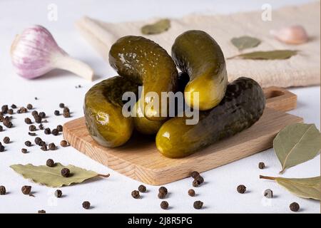 Fermentierte Gurken liegen auf einem Holzschneidebrett Stockfoto
