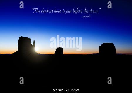 Die Sonne geht über den Buttes in Monument Valley, Utah, USA, mit dem Sprichwort „die dunkelste Stunde steht kurz vor der Morgendämmerung“ auf Stockfoto