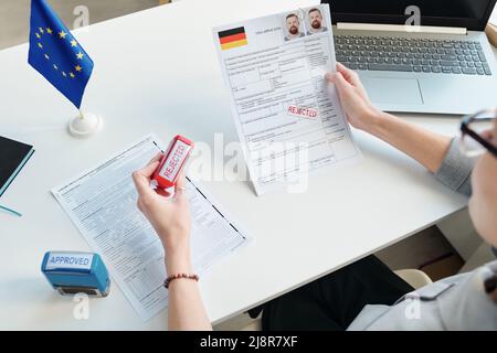 Aufnahme eines nicht erkennbaren Konsularbeamten, der Visumanträge ablehnt und genehmigt Stockfoto