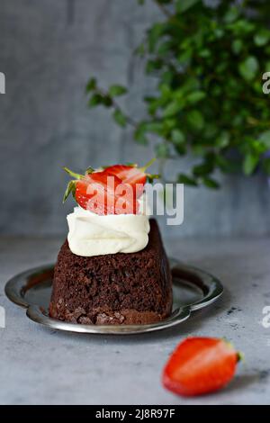 Schokoladenbrownie (Kuchen) mit luftiger Vanillecreme und frischen Erdbeeren (Beeren). Teedessert Stockfoto