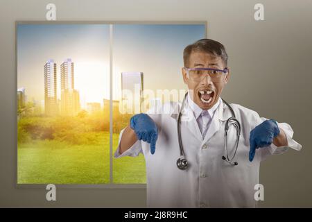 Asiatischer Nerd-Wissenschaftler mit einem Stethoskop, das auf etwas mit Glashintergrund zeigt Stockfoto