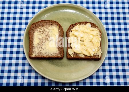 Eiermayonnaise auf Vollkornbrotscheiben und Butter Stockfoto