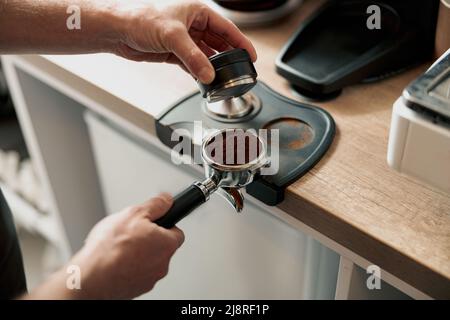 Prozess der Vorbereitung des Kaffeetabletts, bevor es in die Kaffeemaschine eingesetzt wird Stockfoto