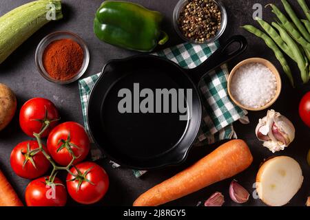 Auswahl an Gemüse, Kräutern und Gewürzen auf schwarzem Stein Hintergrund Stockfoto