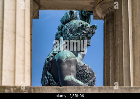 München, Deutschland. 18.. Mai 2022. Die 18 Meter hohe Bavaria-Statue, die über dem Oktoberfest steht, ist vor einem blauen Himmel zwischen den steinernen dorischen Säulen der Ruhmeshalle zu sehen. Kredit: Peter Kneffel/dpa/Alamy Live Nachrichten Stockfoto