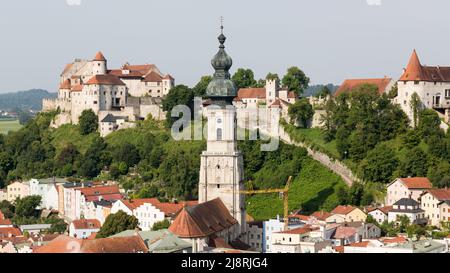 Burghausen, Deutschland - 24. Juli 2021: Kirchturm St. Jakob. Im Hintergrund Burg Burghausen. Stockfoto