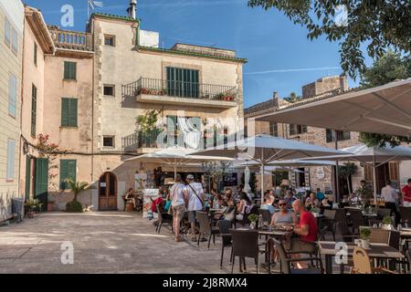 Menschen in Cafés und Restaurants in Placeta de Les Verdure's in der mittelalterlichen Altstadt von Alcudia, Mallorca, Spanien Stockfoto