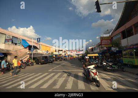 Ein Autofahrer, der auf der Straße fährt und ein Zebrakreuz in einem Gewerbegebiet in Payakumbuh, West Sumatra, Indonesien, überquert. Stockfoto