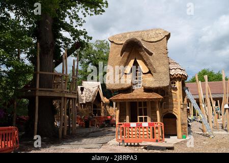 Englefield Green, Egham, Surrey, Großbritannien. 17.. Mai 2022. Ein reetgedeckten Cottage im Bau in einem großen neuen Kinderspielplatz im Savill Garden. Quelle: Maureen McLean/Alamy Live News Stockfoto