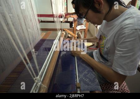 Ein Arbeiter, der ein Songket-Gewebe im Erika Rianti-Songket-Studio in Bukittinggi, West Sumatra, Indonesien, fertigstellt. Stockfoto