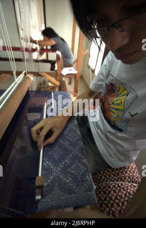 Ein Arbeiter, der ein Songket-Gewebe im Erika Rianti-Songket-Studio in Bukittinggi, West Sumatra, Indonesien, fertigstellt. Stockfoto