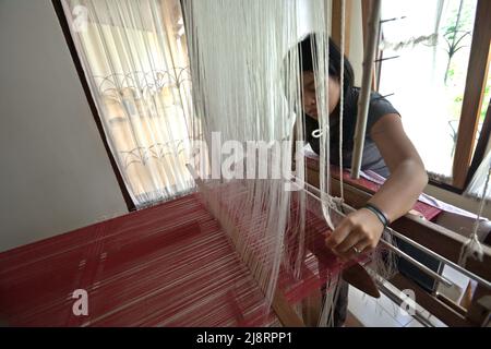 Eine Frau, die im Erika Rianti Songket Studio in Bukittinggi, West Sumatra, Indonesien, Songket Stoff macht. Stockfoto