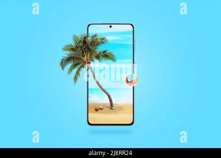 Strand auf einem Mobiltelefon mit einer Palme und einem Ball, der aus dem Display kommt. Kreatives Technologiekonzept mit blauem Hintergrund Stockfoto