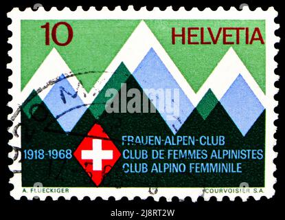 MOSKAU, RUSSLAND - 14. MAI 2022: Briefmarke in der Schweiz zeigt stilisierte Berge und Clubabzeichen, Schweizer Frauen Alpine Club Serie, um 1968 Stockfoto