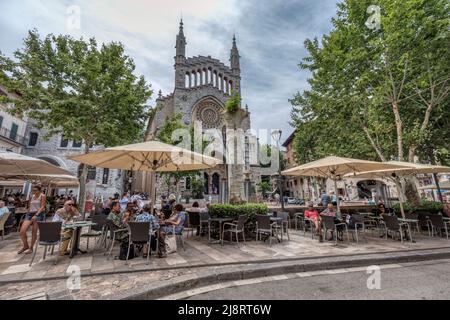 Menschen in Cafés Hauptplatz Placa Constitucio in Soller vor der Kirche Sant Bartomeu im UNESCO-Weltkulturerbe Serra de Tramuntana Berge Stockfoto