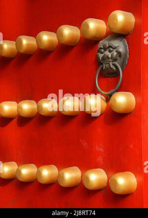 Detail einer traditionellen chinesischen Tür im Xiaoling Mausoleum der Ming-Dynastie in Nanjing, Provinz Jiangsu, China. Rote Tür mit Löwengriff. Stockfoto