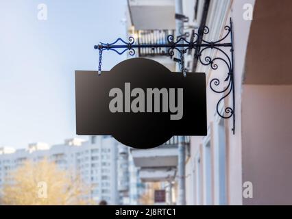 Nachbau, großes schwarzes Schild vor dem Hintergrund des Himmels und des alten Hauses Stockfoto
