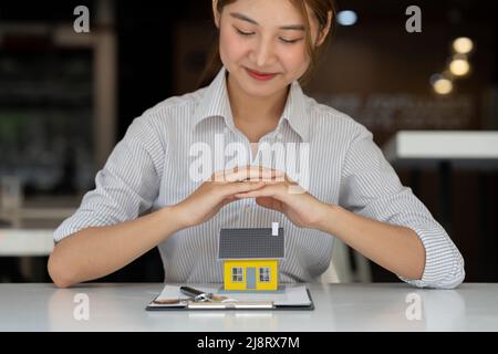 Beschnittene Ansicht des Risikomanagers schützendes Hausmodell. Hausversicherungskonzept. Stockfoto