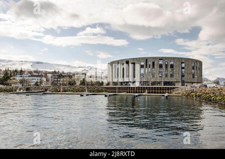 Akureyri, Island, 29. April 2022: Das Kultur- und Konferenzzentrum Hof spiegelt sich im Hafen der Stadt wider Stockfoto