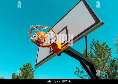 Street Basketball Ball fällt in den Reifen. Urban Youth Spiel. Konzept für Erfolg, Punkte sammeln und gewinnen. Stockfoto