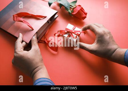 Draufsicht auf die Hand des Mannes, der eine Geschenkbox hält Tabelle Stockfoto