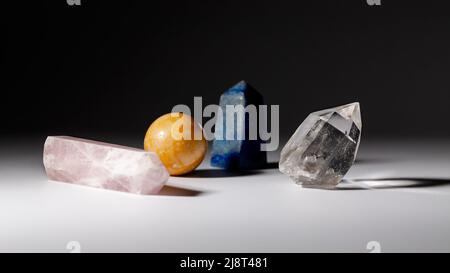 Verschiedene heilende Steinkristalle für Meditation oder spirituelle Praktiken auf grauem Hintergrund. Horizontale Ausrichtung Stockfoto