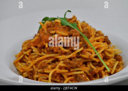 Spaghetti in einem Gericht auf weißem Hintergrund Stockfoto