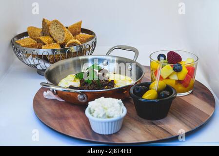 Marokkanisches Frühstück mit weißen Eiern mit Fleisch, Oliven und Obstsalat Stockfoto