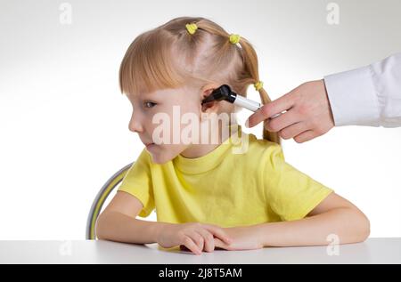 Doktor HNO Arzt führt eine Otoskopie mit einem Gerät, Nahaufnahme. Behandlung und Routineuntersuchung der Ohrmembranen und Gehörgänge. Stockfoto