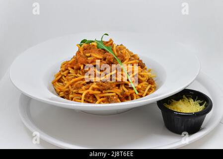 Spaghetti in einem Gericht auf weißem Hintergrund Stockfoto