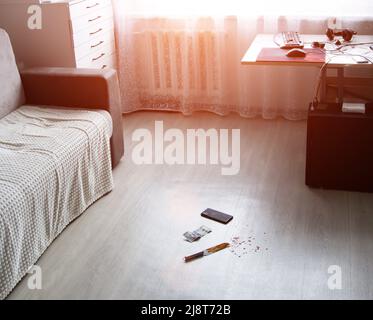 Der Tatort im Zimmer der Wohnung. Messer im Blut, Gelddollar und Smarfton liegen auf dem Boden. Raub und Diebstahl, Kriminalität Stockfoto