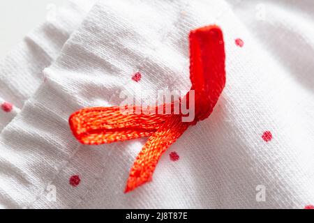 Weiße Kleidung mit roten Mustern und elastischem Band, Textur Stockfoto