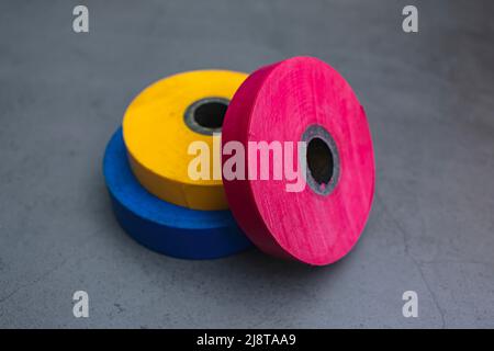 Drei Rollen Isolierband auf dunklem Hintergrund für den Einsatz in Konstruktion und Reparatur Stockfoto