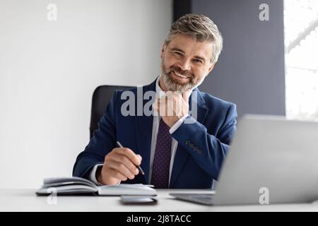 Erfolgreiche Reife Geschäftsmann Tragen Anzug Sitzen Am Schreibtisch Mit Laptop Im Büro Stockfoto