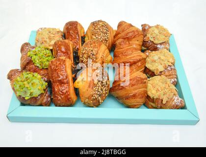 Set mit köstlichen frisch gebackenen Croissants auf weißem Hintergrund, französischem Gebäck Stockfoto