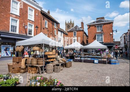 Bunte Straßenszenen auf dem Straßenmarkt von Ludlow inmitten der historischen mittelalterlichen Fachwerkgebäude aus dem 15.. Jahrhundert Stockfoto