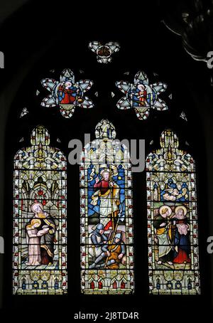 Ein Buntglasfenster von Lavers & Westlake, das die Auferstehung Jesu, Maria, die zum Lesen gelehrt wird, und die Heiligen John & Mary, St. James der große, Dursley darstellt Stockfoto