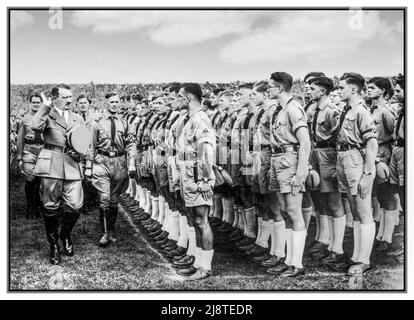 HITLERJUGEND Adolf Hitler begrüßt eine Hitlerjugend-Truppe junger Männer in Uniformen (Shorts, braune Hemden usw.) während der Nürnberger Kundgebung 1935, dem Kongress der NSDAP 7., der vom 10. Bis 16. September in Nürnberg (Nürnberg) stattfand. Hitler wird begleitet von Rudolf Hess, Baldur von Schirach, etc Nazi-Deutschland 1935 Reichsparteitag der NSDAP; Nürnberg, 10.–16. September 1935; Rudolf Heß, Adolf Hitler, Baldur von Schirach, Hitlerjugend Stockfoto