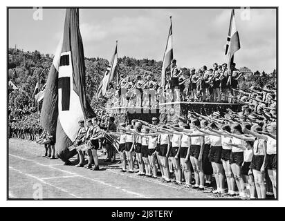 1930s Hitlerjugend Hitlerjugend zusammen mit BDM der Bund Deutscher Mädchen oder die Band Deutscher Mädchenbund Deutscher Mädel, abgekürzt BDM der Mädchenflügel der nationalsozialistischen Jugendbewegung der Hitlerjugend. Es war die einzige legale weibliche Jugendorganisation in Nazi-Deutschland. Gemeinsam auf einem regionalen Sportfest der Hitlerjugend und des BDM in Tübingen auf dem Universitätssportplatz mit Hakenkreuzfahnen und Transparenten, die den Nazi-Gruß Tubingens Nazi-Deutschland 1937 übertrugen Stockfoto