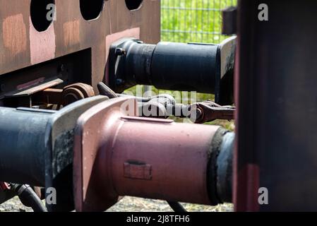 Kettenkupplung verbindet Güterwagen, große Wagenpuffer sichtbar. Stockfoto